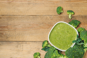 Tasty broccoli soup on a wooden background