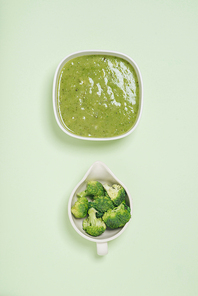 Tasty broccoli soup on a green background