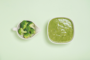 Tasty broccoli soup on a green background