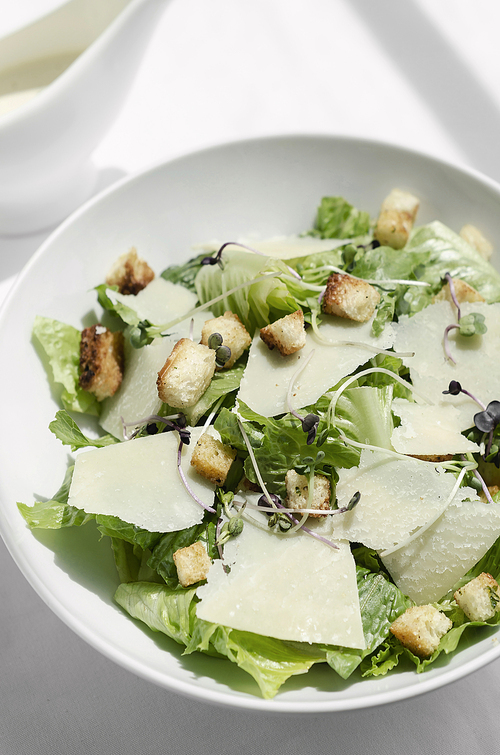 caesar salad with parmesan cheese and croutons on restaurant table