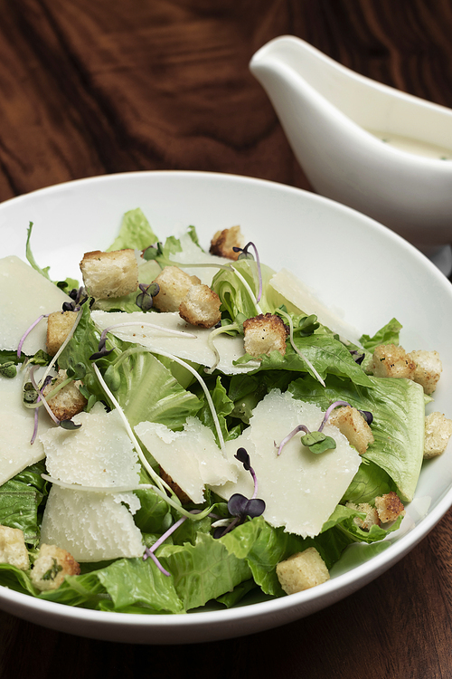 caesar salad with parmesan cheese and croutons on restaurant table