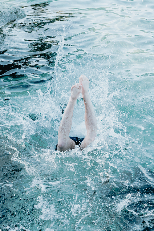 Man splashing into water during a jump, beach and holiday concept, fun and play in beach concept