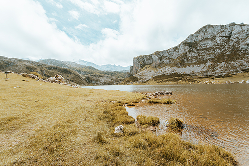 Colorful landscape of the mountains of Asturias during a sunny day, Covadonga lakes, peaceful scenario, snowy mountains, copy space