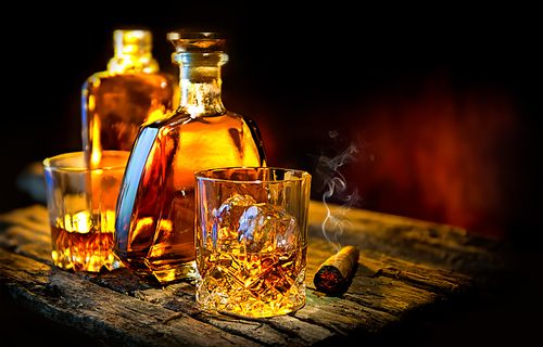 Glass and bottle of whiskey on a wooden table