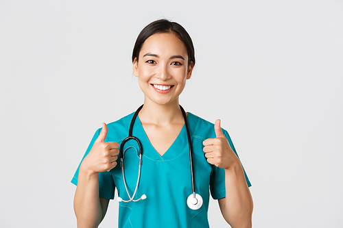 Healthcare workers, preventing virus, quarantine campaign concept. Close-up of upbeat smiling asian doctor, physician looking confident, ensure patient, showing thumbs-up in approval.
