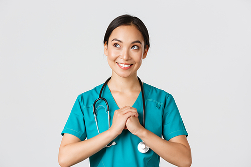 Healthcare workers, preventing virus, quarantine campaign concept. Determined and confident asian female physician in scrubs, clench hands together, getting ready, looking upper left corner.