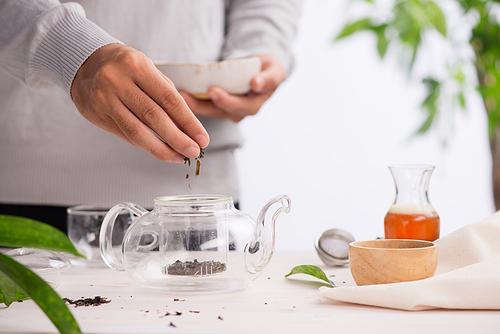 Pouring healthy tea. Hot tea on a glass teapot on a wooden table.