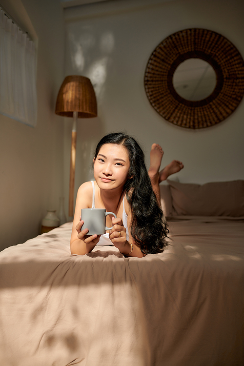 Woman in bed drinking tea. Woman enjoying tea in the bed in the morning.