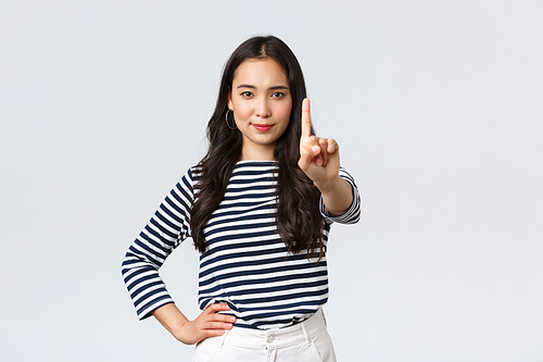 Lifestyle, beauty and fashion, people emotions concept. Wait a sec. Serious-looking confident asian woman scolding someone, shaking index finger to prohibit or disapprove action.