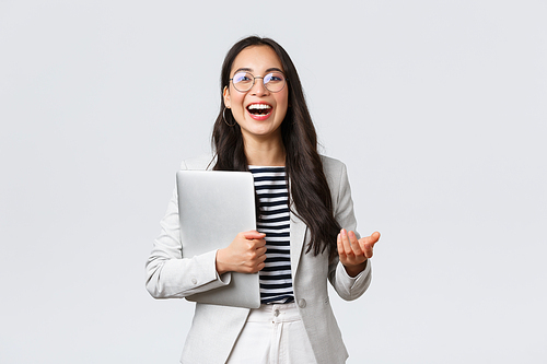 Business, finance and employment, female successful entrepreneurs concept. Laughing pleasant professional businesswoman, real estate broker showing clients good deal, carry laptop in hand.