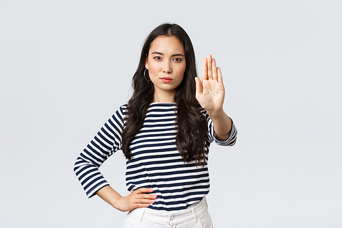 Lifestyle, beauty and fashion, people emotions concept. Serious-looking displeased asian woman tell to stop, extend hand disappointed to prohibit or restrict something bad happening.