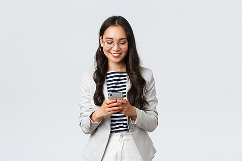 Business, finance and employment, female successful entrepreneurs concept. Businesswoman waiting for client, checking messages in smartphone, wearing glasses as looking at mobile screen.