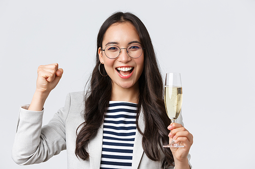 Business, finance and employment, female successful entrepreneurs concept. Happy asian businesswoman celebrating, having office party, drinking champagne, chanting from rejoice, triumphing.