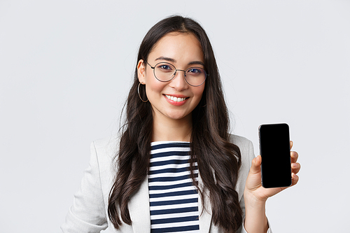 Business, finance and employment, female successful entrepreneurs concept. Close-up of stylish modern asian businesswoman introduce mobile application, showing advertisement in smartphone.