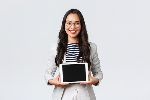 Business, finance and employment, female successful entrepreneurs concept. Friendly smiling real estate broker showing best deal to clients on digital tablet display, working with customers.