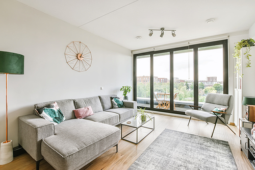 Stunning living area with gray plush sofa and glass coffee table