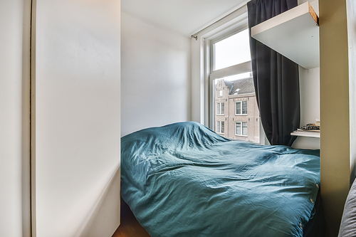 Delightful little bedroom with a soft bed covered with a blue fluffy bedspread