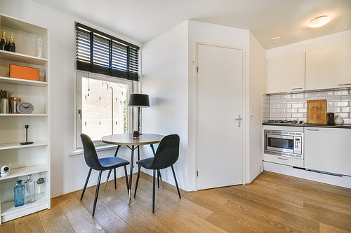 Delightful little dinette near the window with black chairs