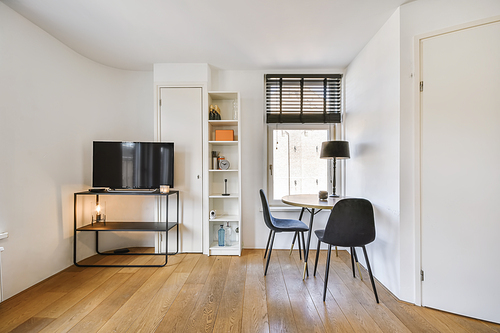 Delightful little dinette near the window with black chairs