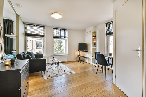 Delightful living room with black comfortable sofa with round coffee table