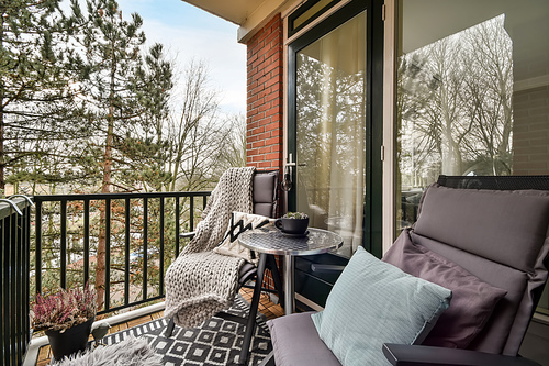 Cozy balcony with a seating area for relaxation and an iron fence