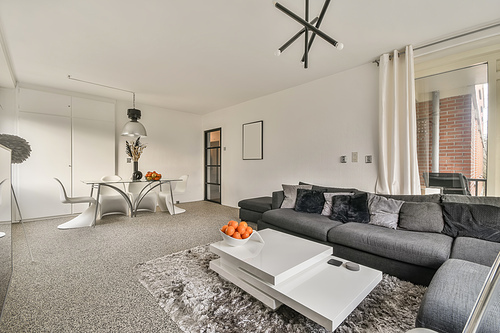 The interior of a modern living room with a large sofa and a dining area in a cozy house