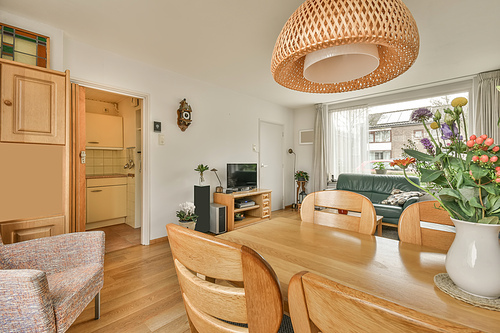 The interior of the living room with sofa in front of the TV and a dining area in a cozy house