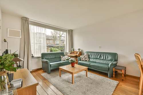 The interior of the living room with two sofas in front of the TV near to the big window in a cozy house