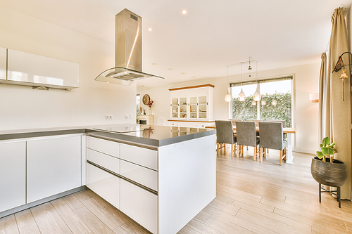 View of bright kitchen with window, shelf and table