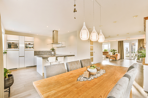 Interior of sitting room with kitchen and large wooden table