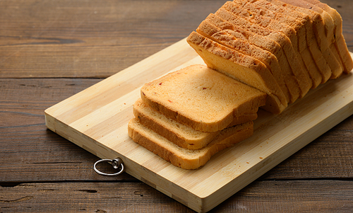 sliced white wheat flour bread on a wooden board. Sandwich bread