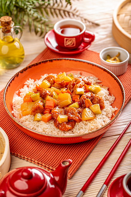 Chicken breast with pineapple cubes in sweet and sour sauce garnished with boiled rice