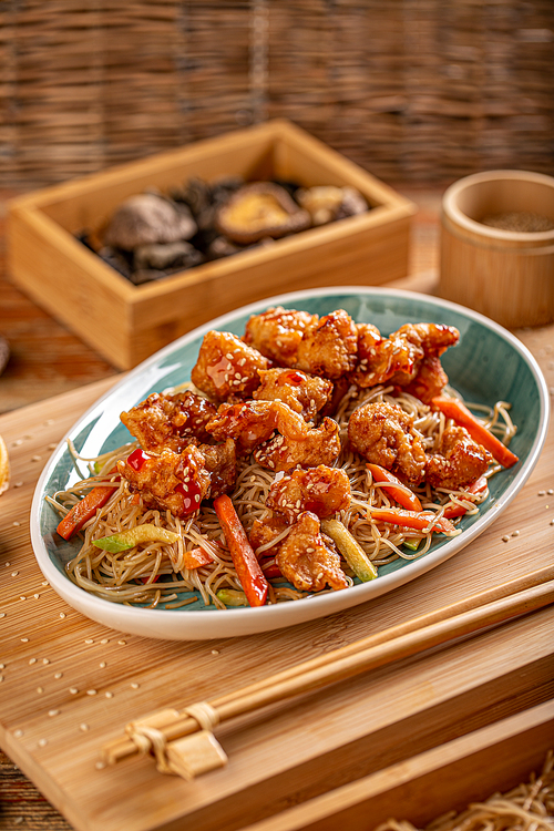 Sweet and sour chicken served with fried noodles and  vegetable
