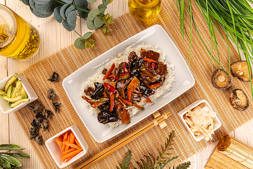 Flat lay of mix vegetable, shiitake and bamboo shoots in spicy brown sauce served with rice