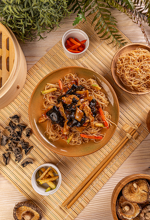 Top view of noodles stir fry with ear wood mushrooms, chicken breast and vegetables