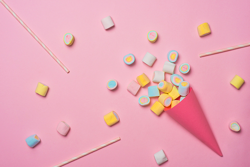 Minimal flat lay. Top view of the pastel marshmallows on a pinkbackground.