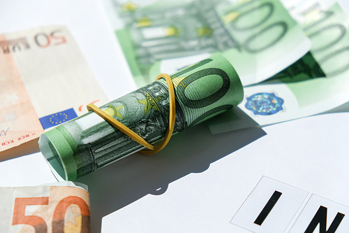 Close up of Euro money roll. Euro banknote set cash money - EU currency. Rolled with rubber euro notes. Business budget of wealth and prosperity finance. Banknotes stacked on each other in different positions.