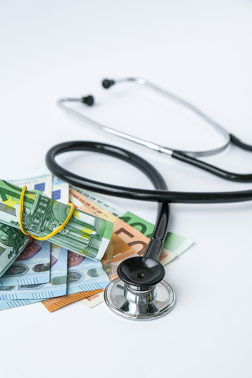 Stack of cash euros and stethoscope. The concept of medical expensive medicine, doctors salary. Copy space for text. Health Life insurance. vaccination costs. Financial crisis. Covid-19 crimes