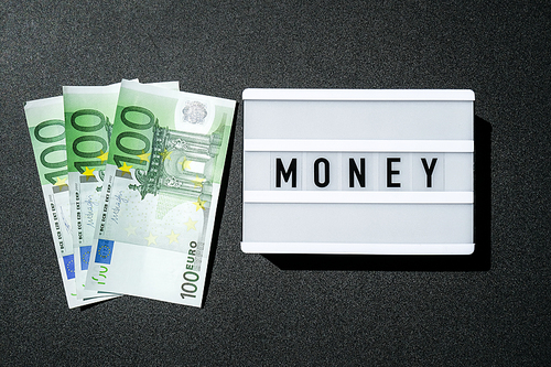 Lightbox board with the word MONEY in black letters around Euro banknotes. Finance background. Business, financial success and making money concept. Business budget of wealth and prosperity finance. Euros Cash Bill