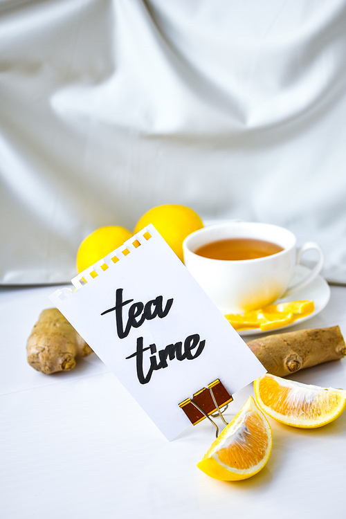 TEA TIME - written on piece of paper among the products for the treatment of common cold - lemon, ginger, chamomile tea. Vitamin natural drink. Cinnamon anise star.