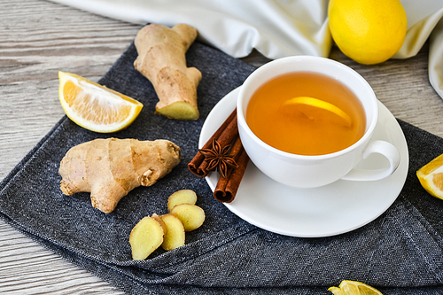 Ginger hot immunity boosting Vitamin natural drink With citrus lemon cinnamon anise in a rustic style on wooden background. Chamomile tea. Healthy concept