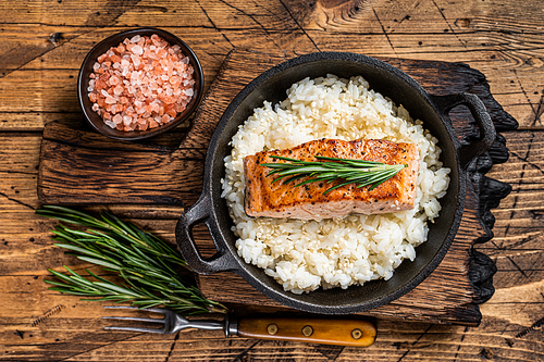 Grilled Salmon Fillet Steaks with white rice in a pan. wooden background. Top view.