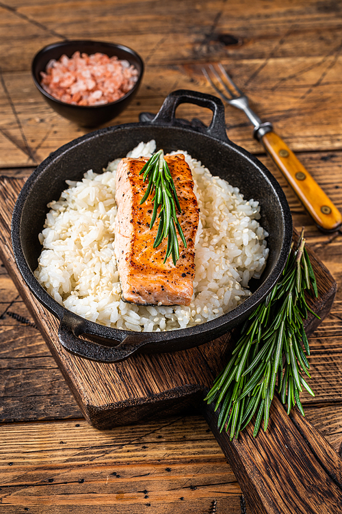 Grilled Salmon Fillet Steaks with white rice in a pan. wooden background. Top view.