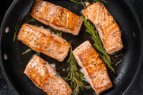 Grilled Salmon Fillet Steak in a pan. Black background. Top view.