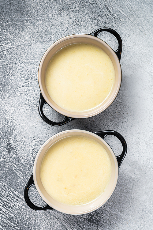 Homemade potato cream soup in bowls. White background. Top view.