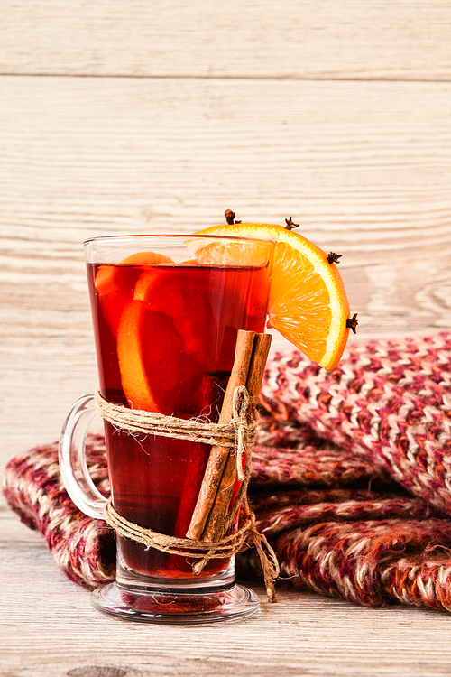 Mulled wine Hot christmas drink with spices on wooden background. Orange slice, cinnamon sticks, sweater. Christmas morning. Holiday atmosphere, Rustic style. The idea for creating greeting cards