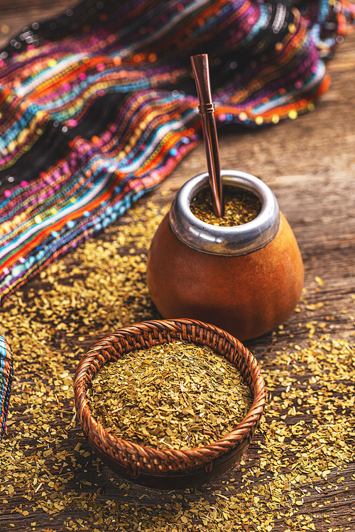 Yerba mate-South American tea, dried leaves in wooden bowl with a wooden mate calabash with tea