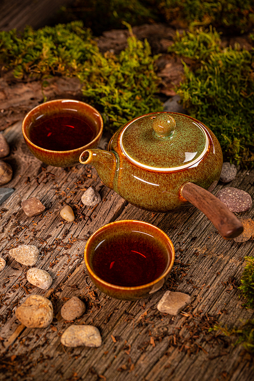 Cup of tea and teapot on vintage wooden background