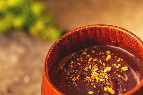 Mug of hot chocolate with pistachio, close up shot