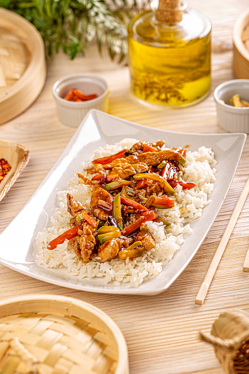 Stir frying chicken with vegetables garniched with white boiled rice